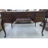 An early 20thC French carved oak kneehole desk with a parquetry top,