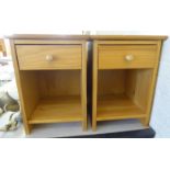 A pair of modern honey coloured pine bedside cupboards, each with a single drawer,