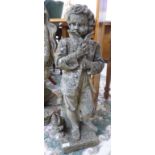 A composition stone garden ornament, a boy wearing a jacket,