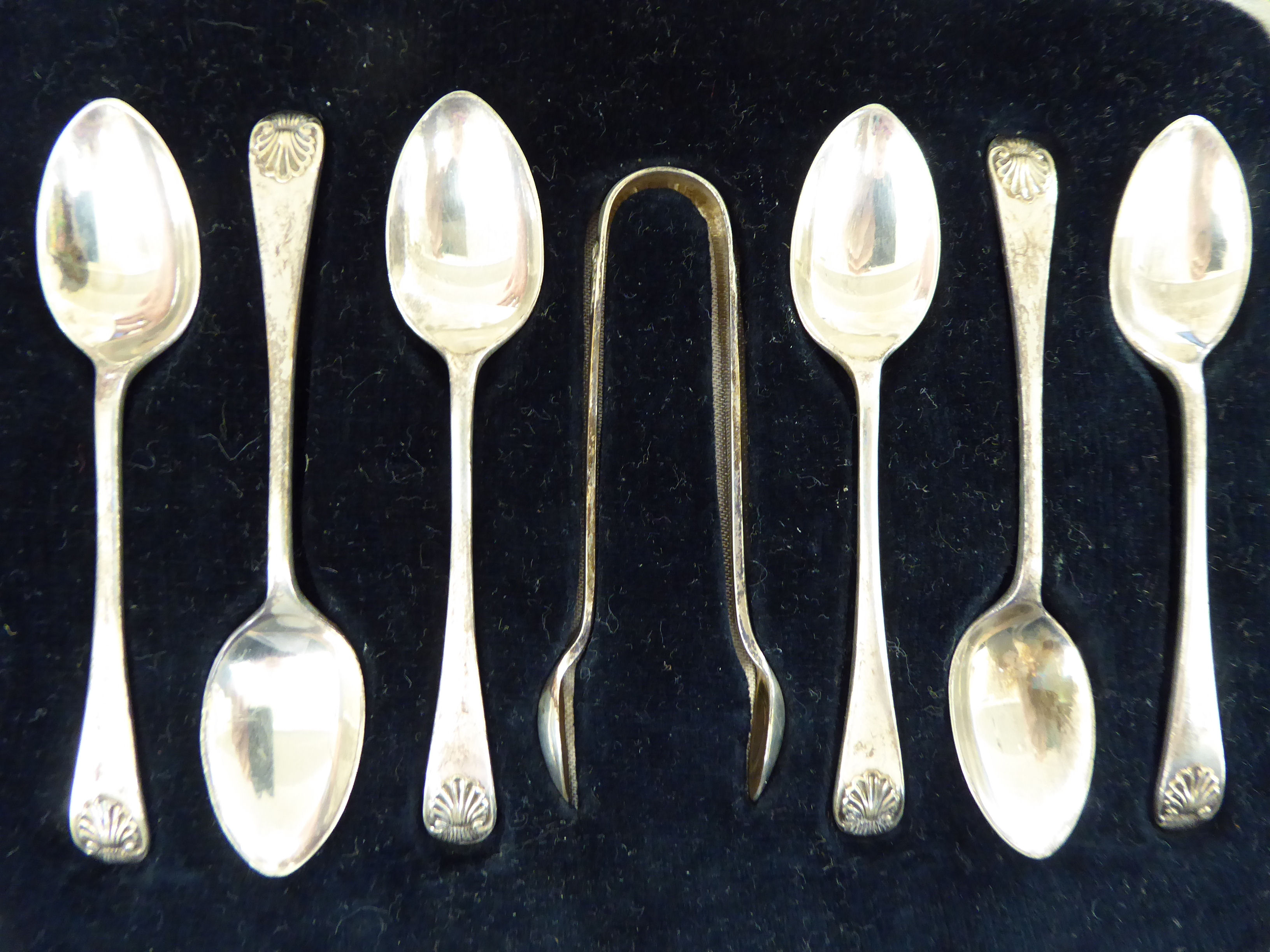 A set of six silver teaspoons with shell cast terminals;