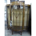 An Art Deco walnut and mahogany finished display cabinet with a glazed front panel,