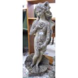 A composition stone garden ornament, a standing nude in a shell,