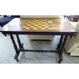 An early Victorian mahogany games table, the top incorporating a chessboard, raised on ring turned,