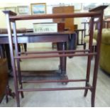 An Edwardian mahogany freestanding towel rail, comprising three tiers of parallel bars,