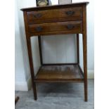 An early 20thC light oak bedside table with two shallow drawers, over an open undershelf,