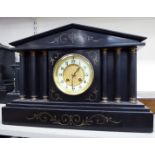 A late Victorian black slate mantel clock of architectural form;