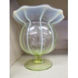 A vaseline glass vase of segmented, bulbous form with a wide, wavy rim,