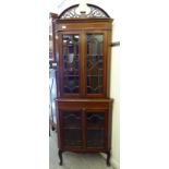 An Edwardian satinwood inlaid mahogany corner cabinet with an arched fretworked cornice,