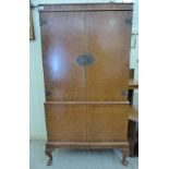 A modern crossbanded and burr walnut finished cocktail cabinet, having a pair of doors,