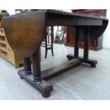 A 1930s oak refectory style dining table, the top with fall flaps,
