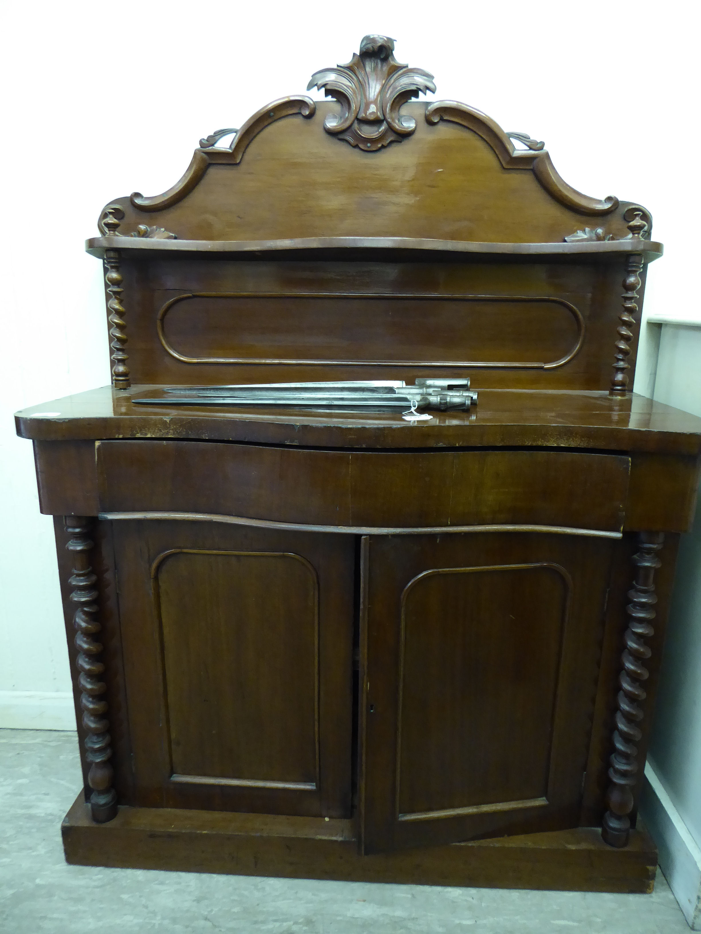 A late Victorian mahogany chiffonier with a raised back, over a frieze drawer and two doors,