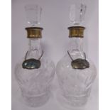 A pair of lead crystal decanters and stoppers with slice and petal cut ornament and silver mounted