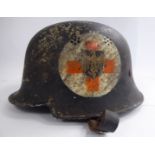 A German black painted Army medic's helmet with a hide lining and chinstrap and bears Nazi and Red