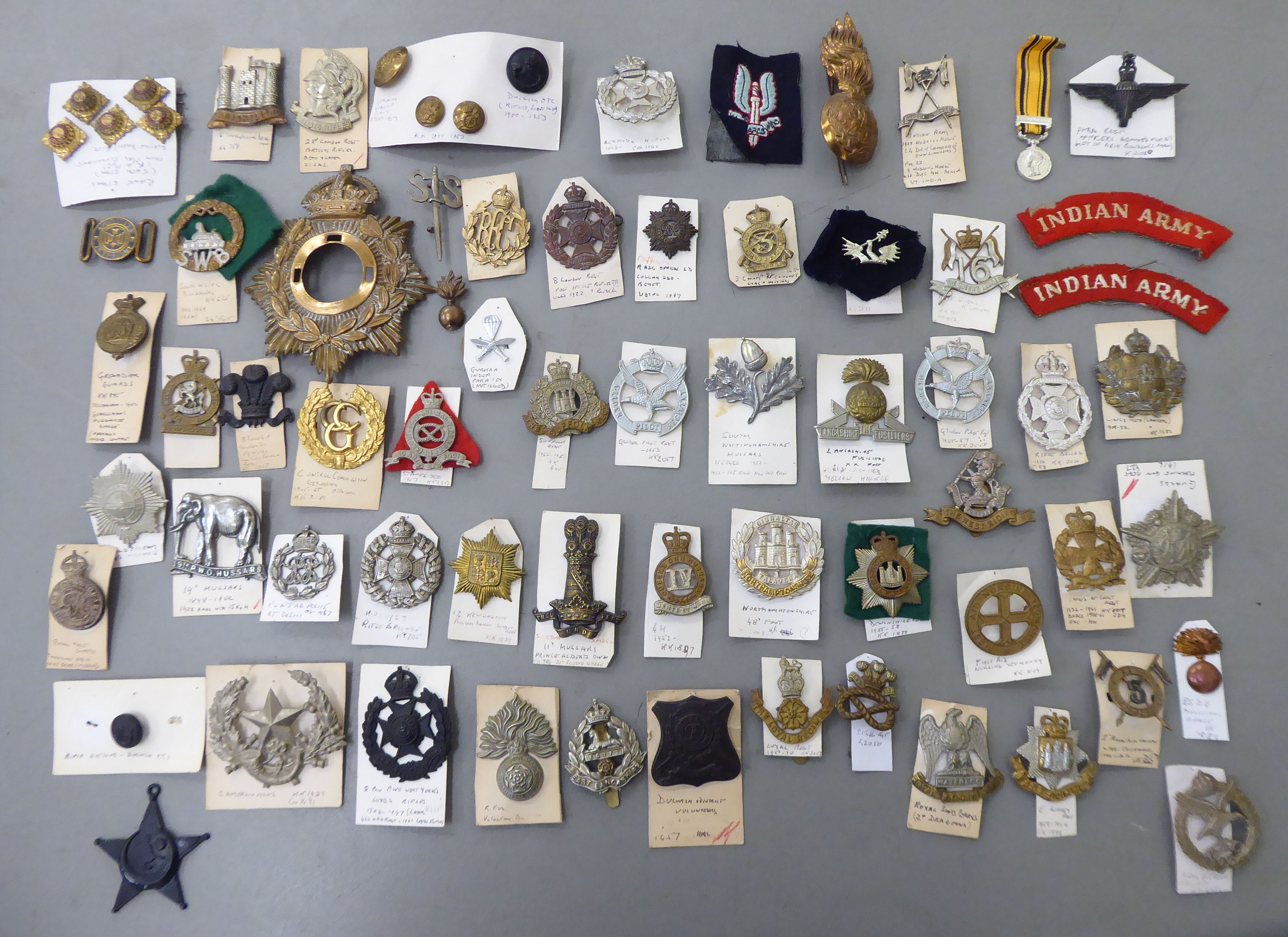 Over fifty military related cap badges and other emblems,