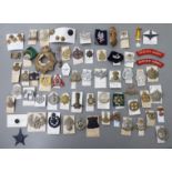 Over fifty military related cap badges and other emblems,