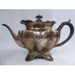 An Edwardian Art Nouveau inspired silver teapot of serpentine outlined,