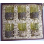 A set of six tinted green tot glasses with fern style and line engraved ornament,