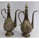 Two similar Persian silver coloured metal pedestal wine ewers of ovoid form with high, swept spouts,