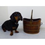 A traditionally constructed coopered oak oval bucket with rivetted brass bands and a hollow,