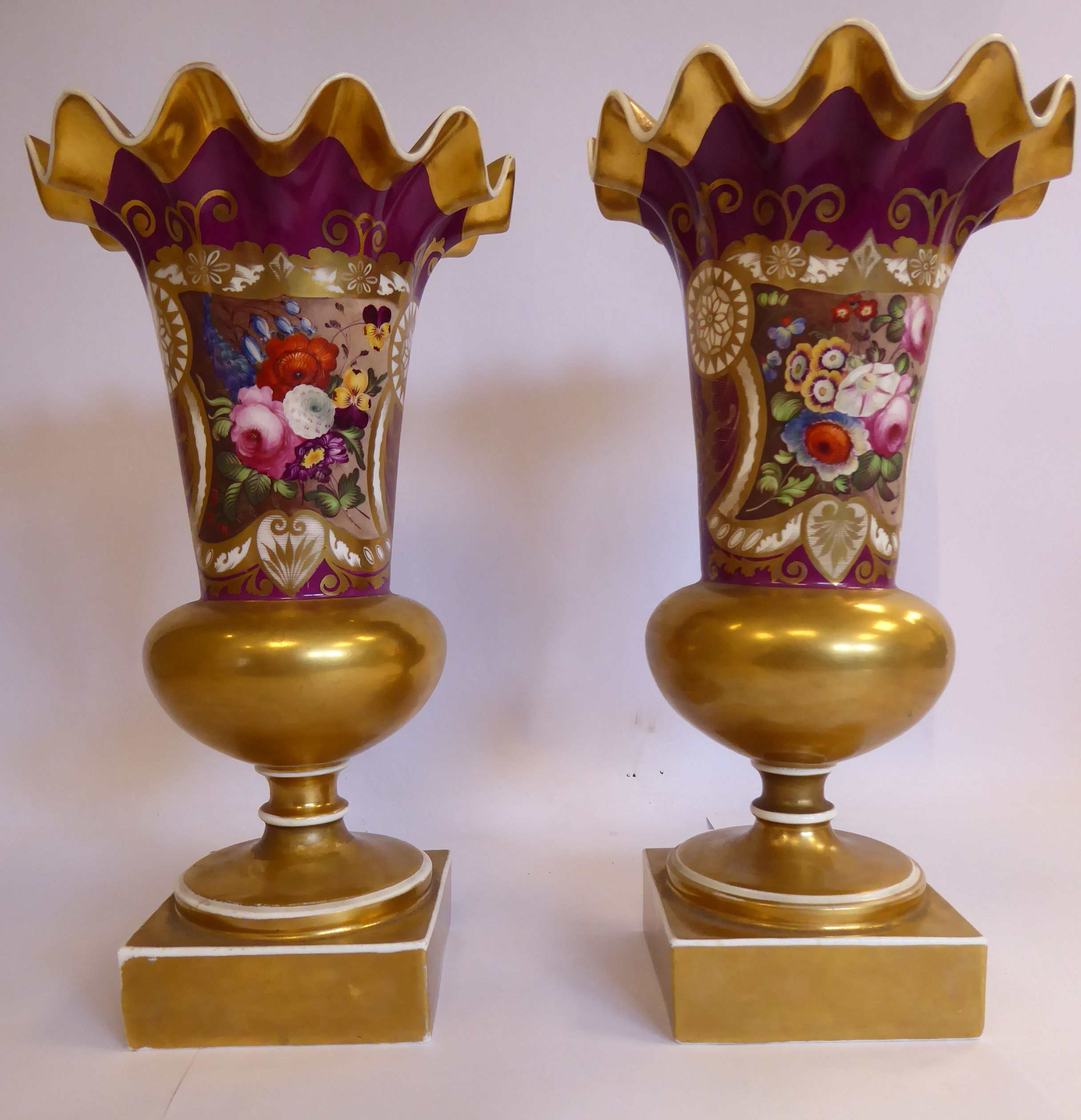 A pair of late 19thC gilded and puce coloured porcelain pedestal vases of bulbous form, having wide,