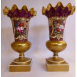 A pair of late 19thC gilded and puce coloured porcelain pedestal vases of bulbous form, having wide,