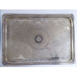 An Iraqi silver coloured metal tray, having a raised border and opposing handles,