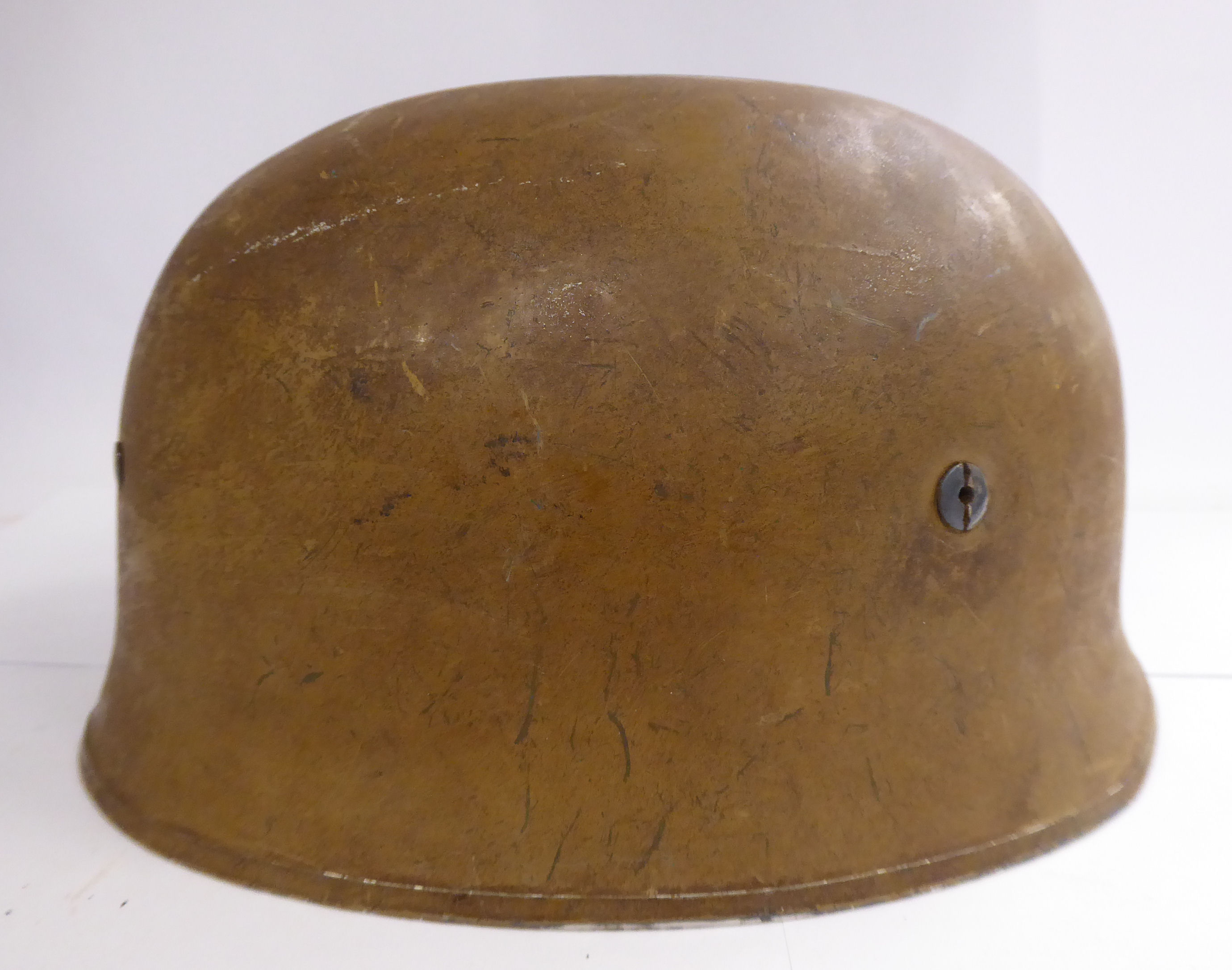 A German brown painted parachutist's helmet with a hide lining and chinstrap (Please Note: this