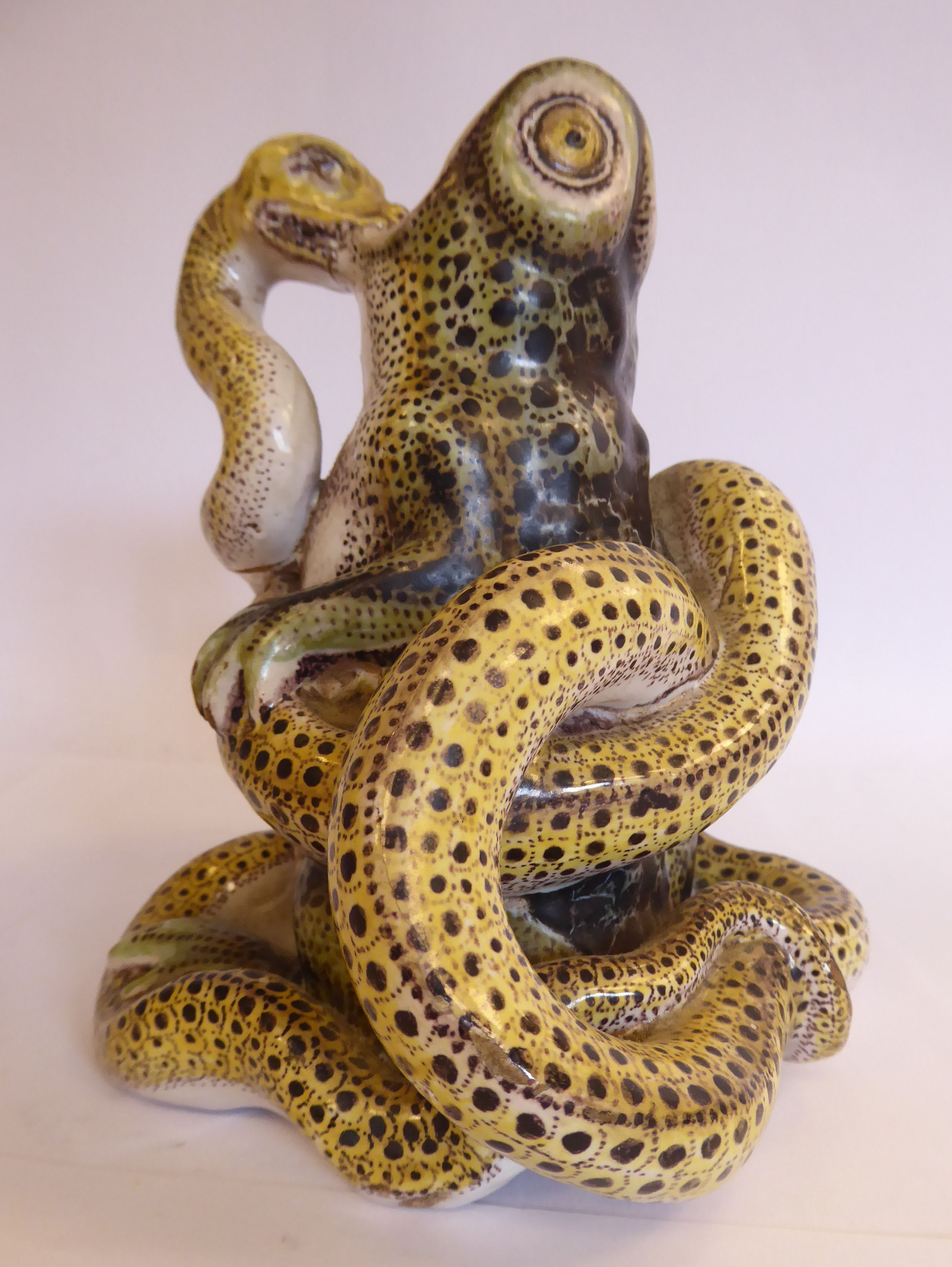 A late 19thC Continental glazed earthenware model, a toad under attack by a python 6.