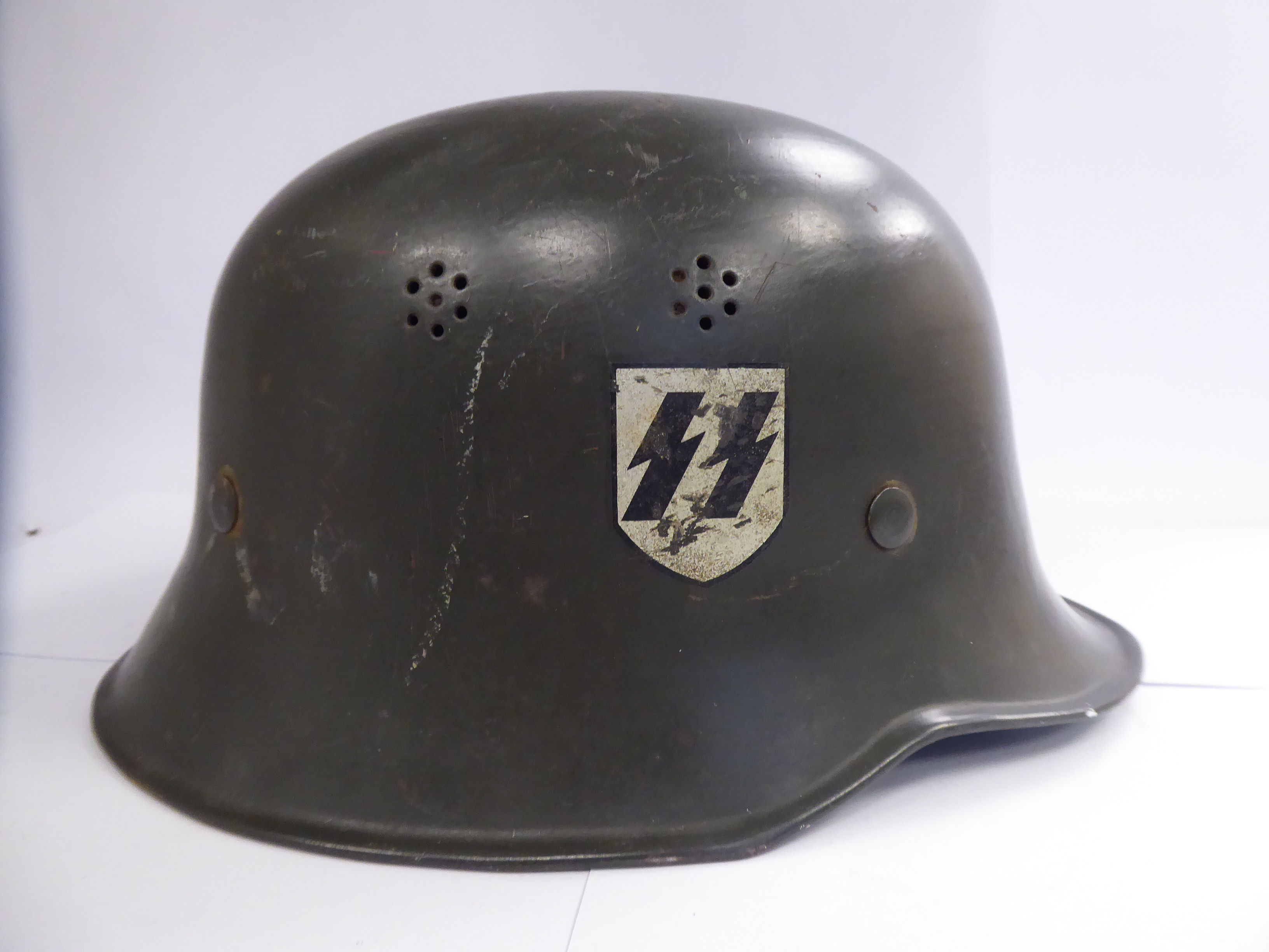 A German green painted SS helmet with a hide lining and decals (Please Note: this lot is offered