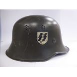 A German green painted SS helmet with a hide lining and decals (Please Note: this lot is offered