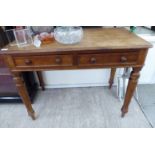 A late Victorian mahogany writing table, the two in-line frieze drawers with bun handles,