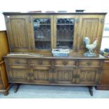 A modern Old English style oak dresser, the superstructure with two central glazed doors,