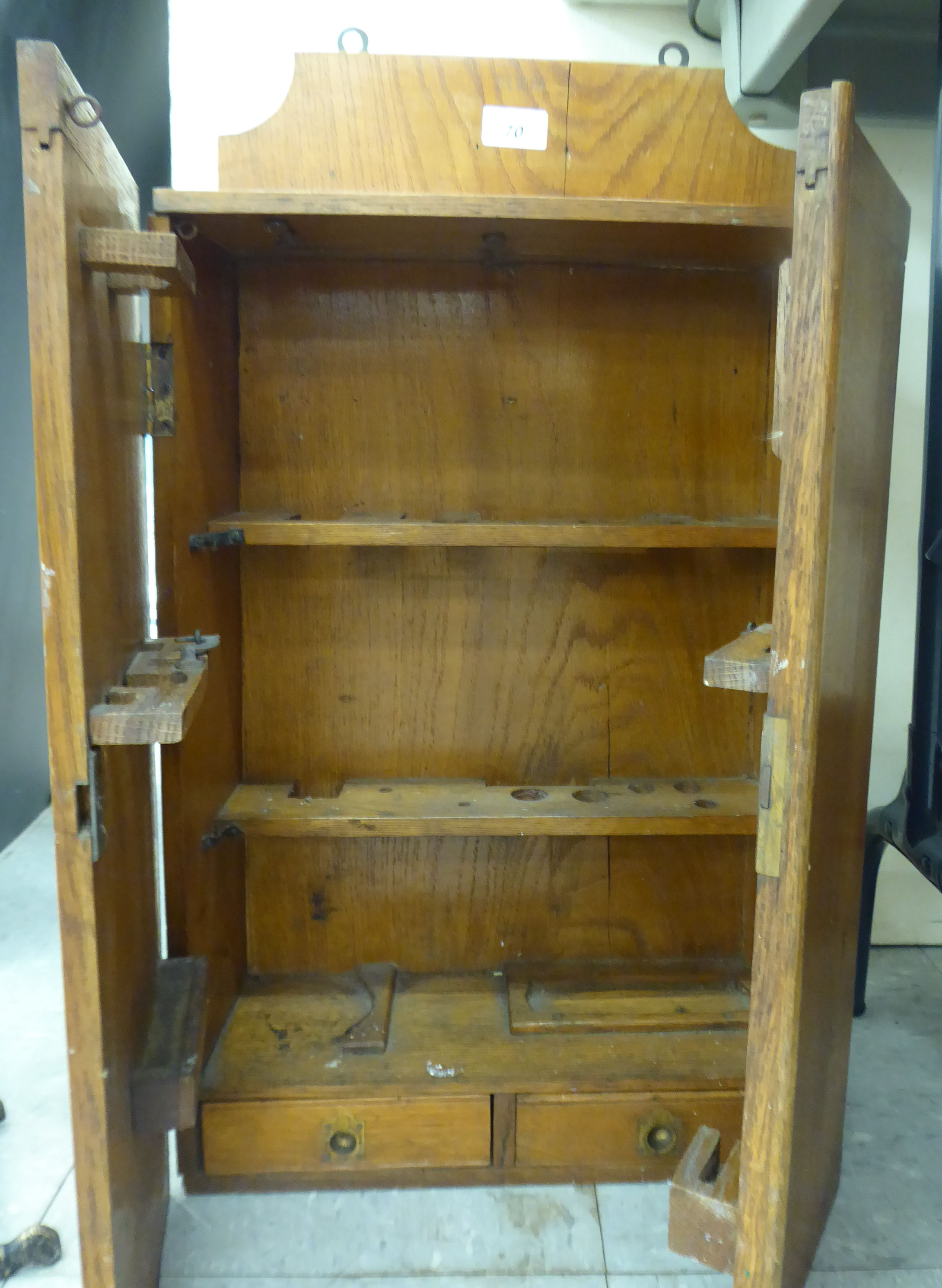 An Edwardian oak smoker's cabinet with two doors, enclosing a fitted interior,