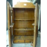 An Edwardian oak smoker's cabinet with two doors, enclosing a fitted interior,