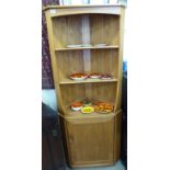 An Ercol elm standing corner cupboard, the superstructure comprising two open shelves,