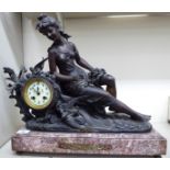 An early 20thC French mantel clock, the patinated spelter case featuring a seated,