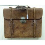 An early 20thC stitched brown hide attache case with buckled straps and a lockable flap OS10