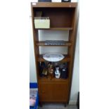 A 1970s teak finished room divider, comprising four open shelves, over a cupboard,