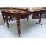 A late Victorian mahogany wind-out dining table, the top with a moulded edge, raised on turned,