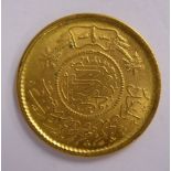 A Persian gold coloured metal coin with a milled border