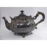 An Edwardian silver teapot of oval form, decoratively cast and chased with foliage and scrolls,