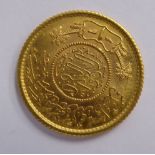 A Persian gold coloured metal coin with a milled border