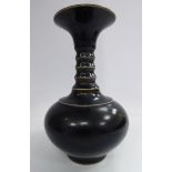 A 20thC Chinese black glazed porcelain bottle vase of squat, bulbous form with a uniformly ribbed,