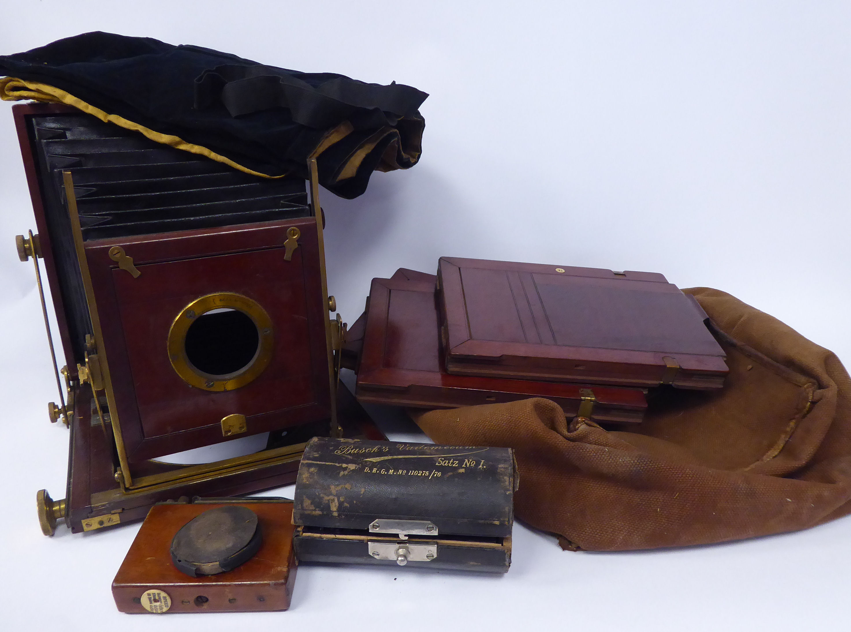 A late 19thC lacquered brass moulded mahogany plate camera with a cased Busch's Vadermecium Satz.No.
