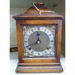 A Georgian style mahogany cased bracket clock, having a folding brass handle on the domed top,