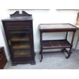 An Edwardian mahogany serpentine front music cabinet with glazed doors,