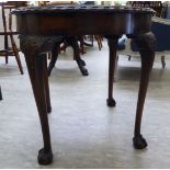 A 1930s mahogany coffee table, raised on cabriole legs,