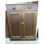 A mid 20thC stained pine cupboard, comprising two in-line drawers,