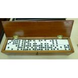 A set of 20thC bone and ebony dominos, in a mahogany box 2.5''h 12.