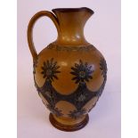 A Doulton Lambeth pale brown and green glazed stonewre jug of ovoid form, having a high loop handle,